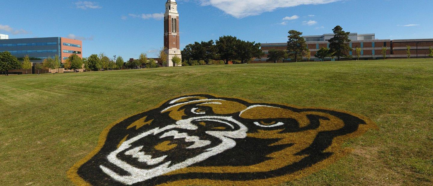 grizz head logo painted on the grass outside of the athletics building