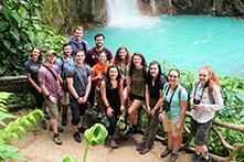 Group of students standing in front of waterfall