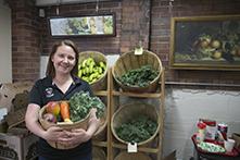 詹妮弗·卢卡雷利在市场上提着一篮子水果和蔬菜的照片